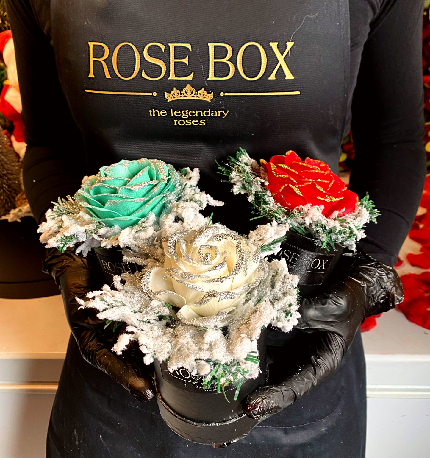 Cutie mică neagră de Crăciun cu un trandafir mare cu sclipici și brad